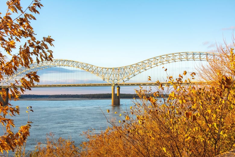 An aerial view of the Memphis bridge and riverfront, representing the East Memphis home community of Opus East Memphis senior living, near the Dixon Gallery, Gardens, and Memphis Botanic Garden.