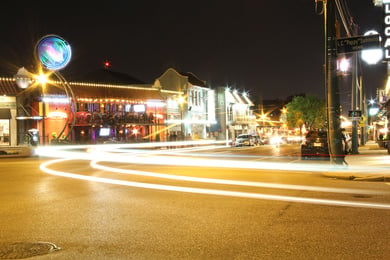 A lively Memphis street glows with restaurant and shop lights at night, reflecting the vibrant dining and entertainment scene near Opus East Memphis senior living in East Memphis, TN.