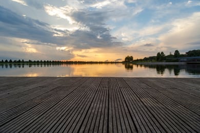 A peaceful wooden dock overlooks a glowing lake at sunset near Opus East Memphis, reflecting the scenic outdoor surroundings that complement senior living near Shelby Farms Park in Memphis, TN.