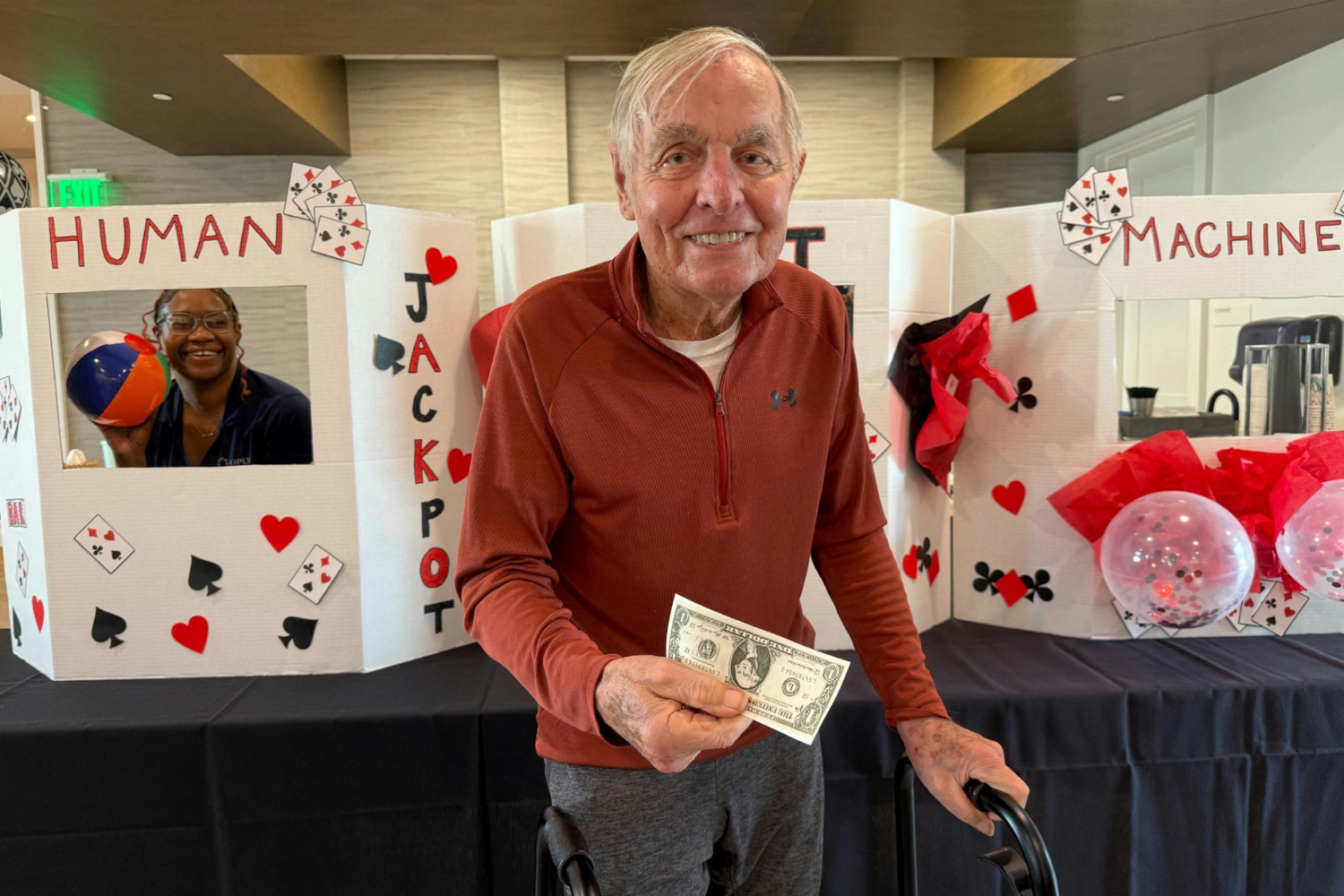 Male residents of Opus East Memphis holding a dollar in front of human slot machine