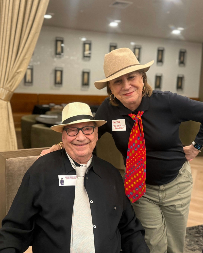 Two people dressed in festive themed outfits pose together in a common area at Opus East Memphis, showcasing the fun, creative events that bring the senior living community in Memphis, TN to life.
