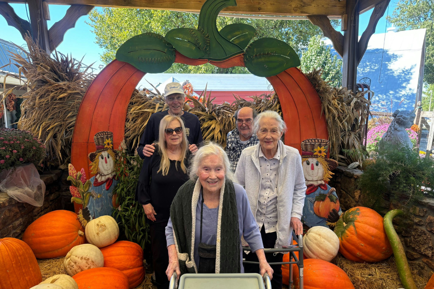 Senior residents posing under archway at pumpkin patch