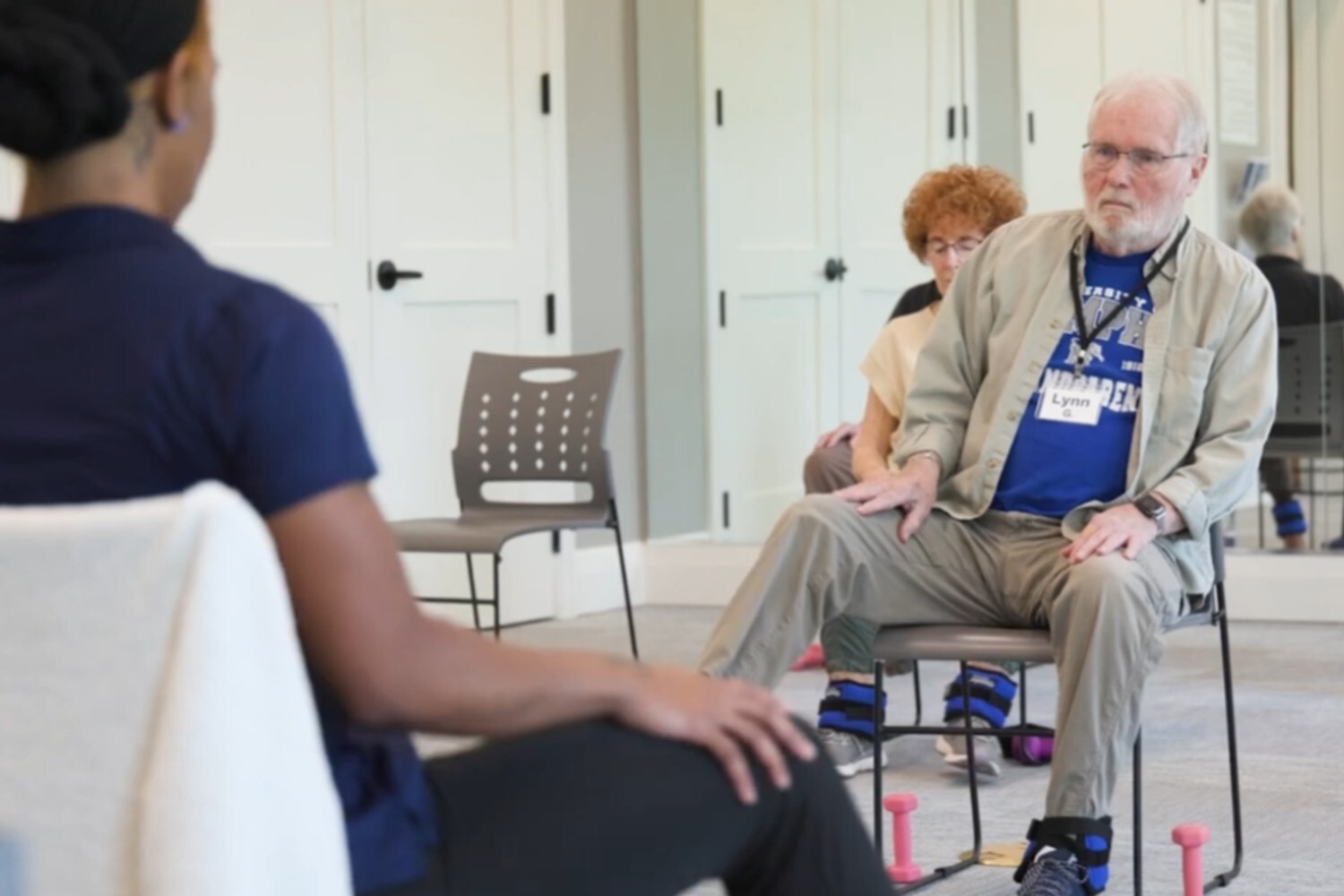 A resident engages in a seated exercise session with a staff member at Opus East Memphis, reflecting the personalized, wellness-focused senior living experience Memphis TN families value.