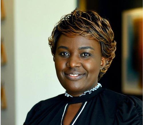 A smiling staff member at Opus East Memphis, a retirement community in East Memphis, TN, photographed indoors with a warm, confident expression.