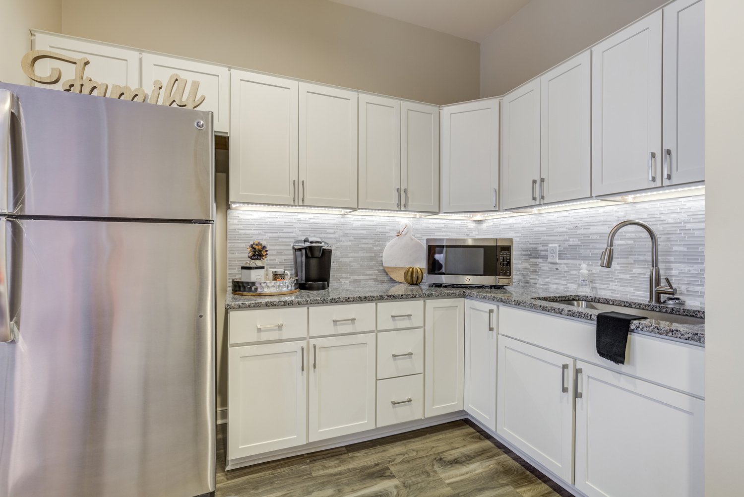 Modern kitchenette at Arbor Terrace Prince William Commons with stainless appliances and granite counters, part of comfortable senior housing in Woodbridge VA.