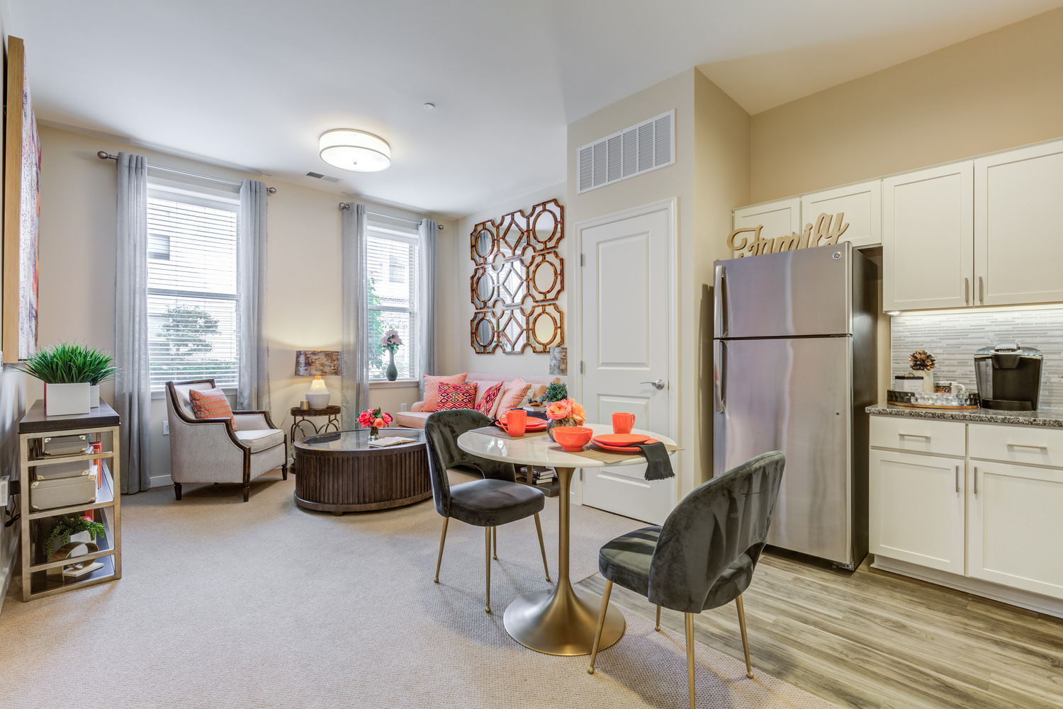 Bright residential suite at Arbor Terrace Prince William Commons with a full kitchenette and cozy living area, offering comfortable senior housing in Woodbridge VA.