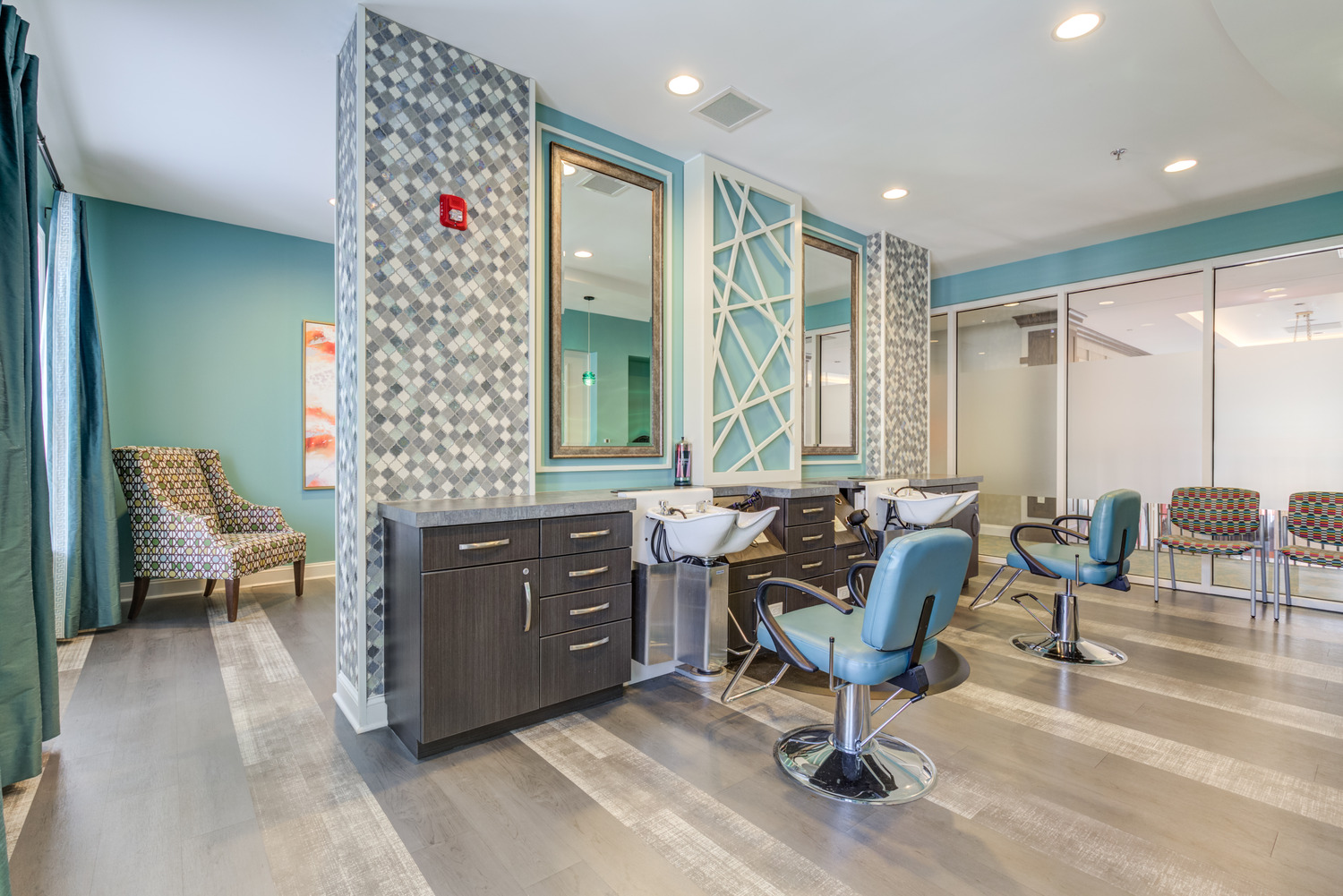 A bright, full-service salon with styling chairs, mirrors, and modern tile accents offers on-site beauty services, part of the walkable senior living Woodbridge VA convenience within this active senior community Prince William County.