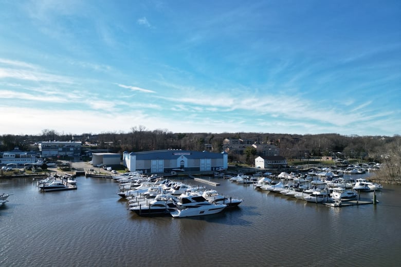 A scenic marina filled with docked boats sits along a calm waterfront under a bright sky, capturing the riverside charm of senior living Occoquan VA and this nature-access senior living Woodbridge lifestyle.