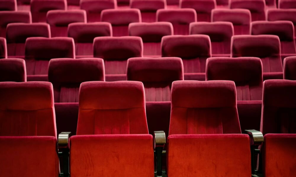 Rows of plush red theater seats invite entertainment and shows, reflecting the engaging senior lifestyle programs near Sandy Springs, GA and Buckhead, GA.