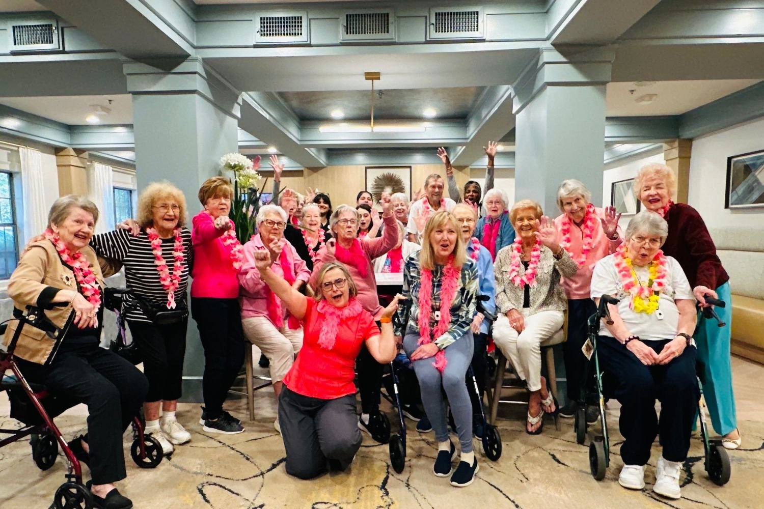 women/residents wear pink and pose in a group while smiling