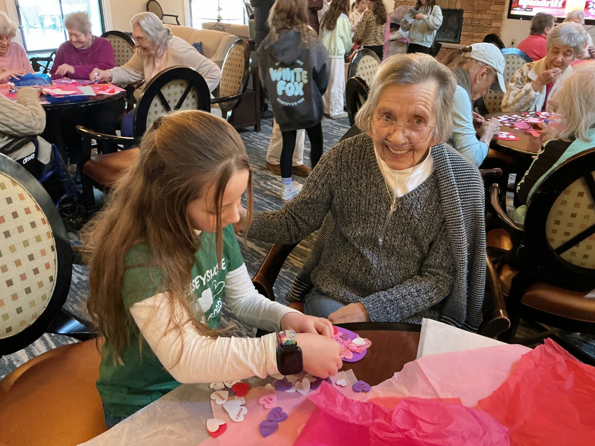 A resident and volunteer create valentine hearts