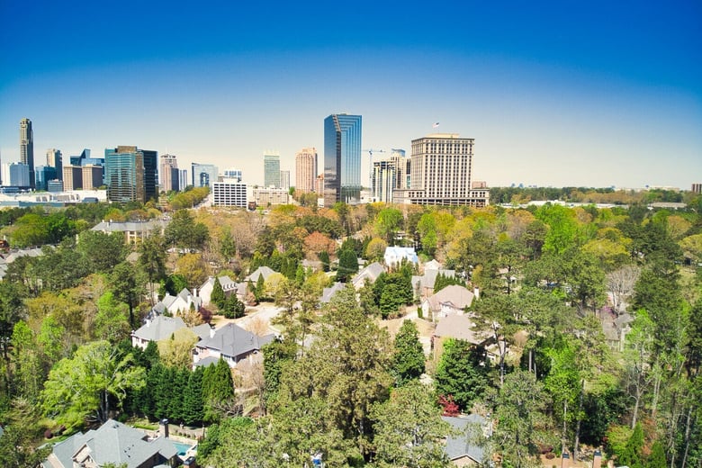 A modern city skyline rises above lush greenery, capturing the dynamic energy near senior living in Sandy Springs, GA and Buckhead, GA.