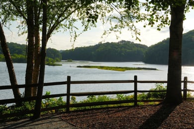 A tranquil river view framed by a wooden fence and trees offers a peaceful natural backdrop, reflecting the scenic senior living in Sandy Springs, GA and Dunwoody, GA.