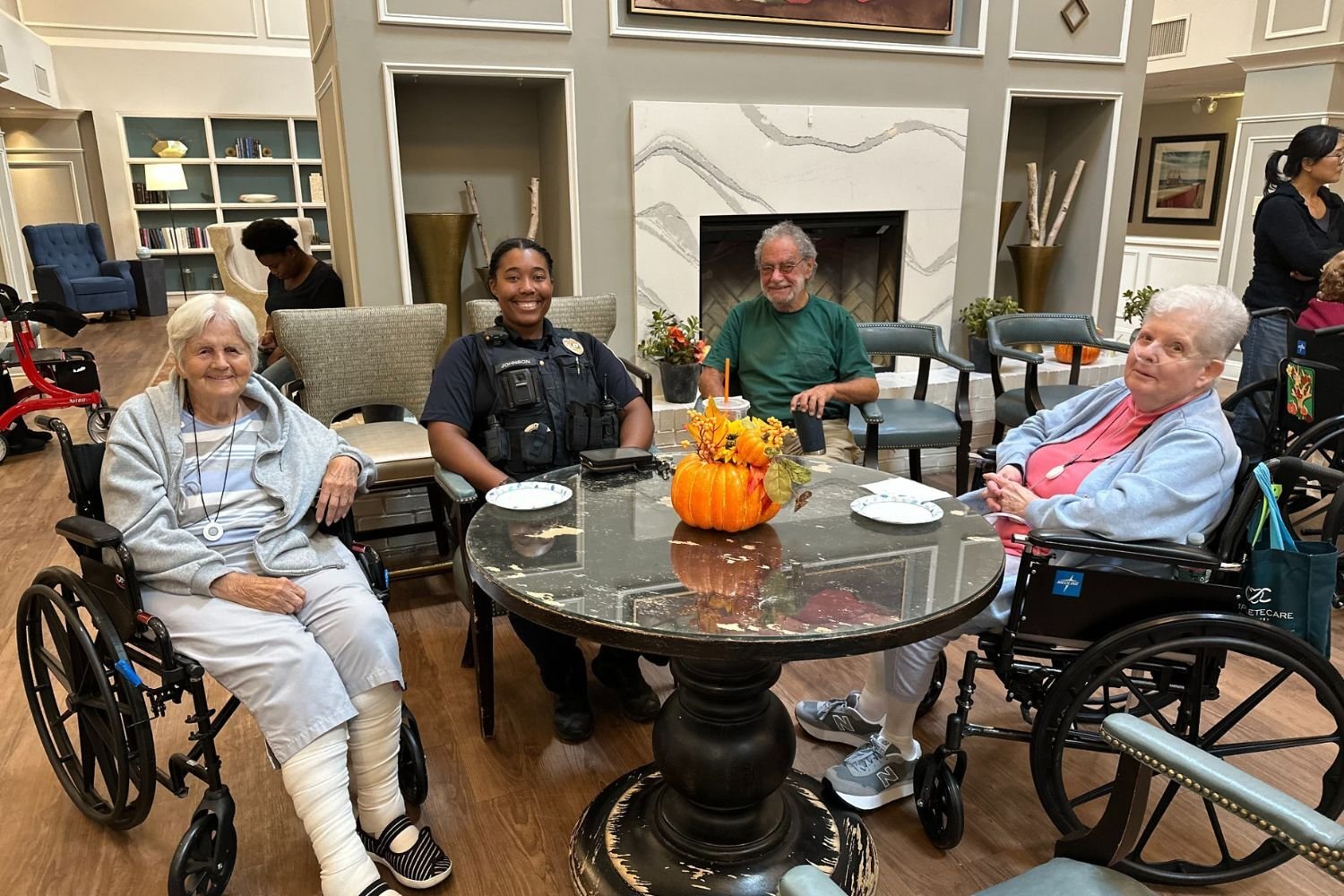 residents sit around a table with a woman cop