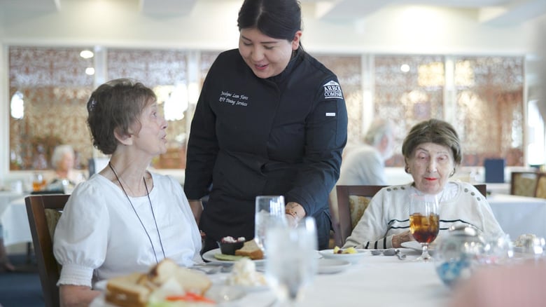 Staff member serving residents in the dining room