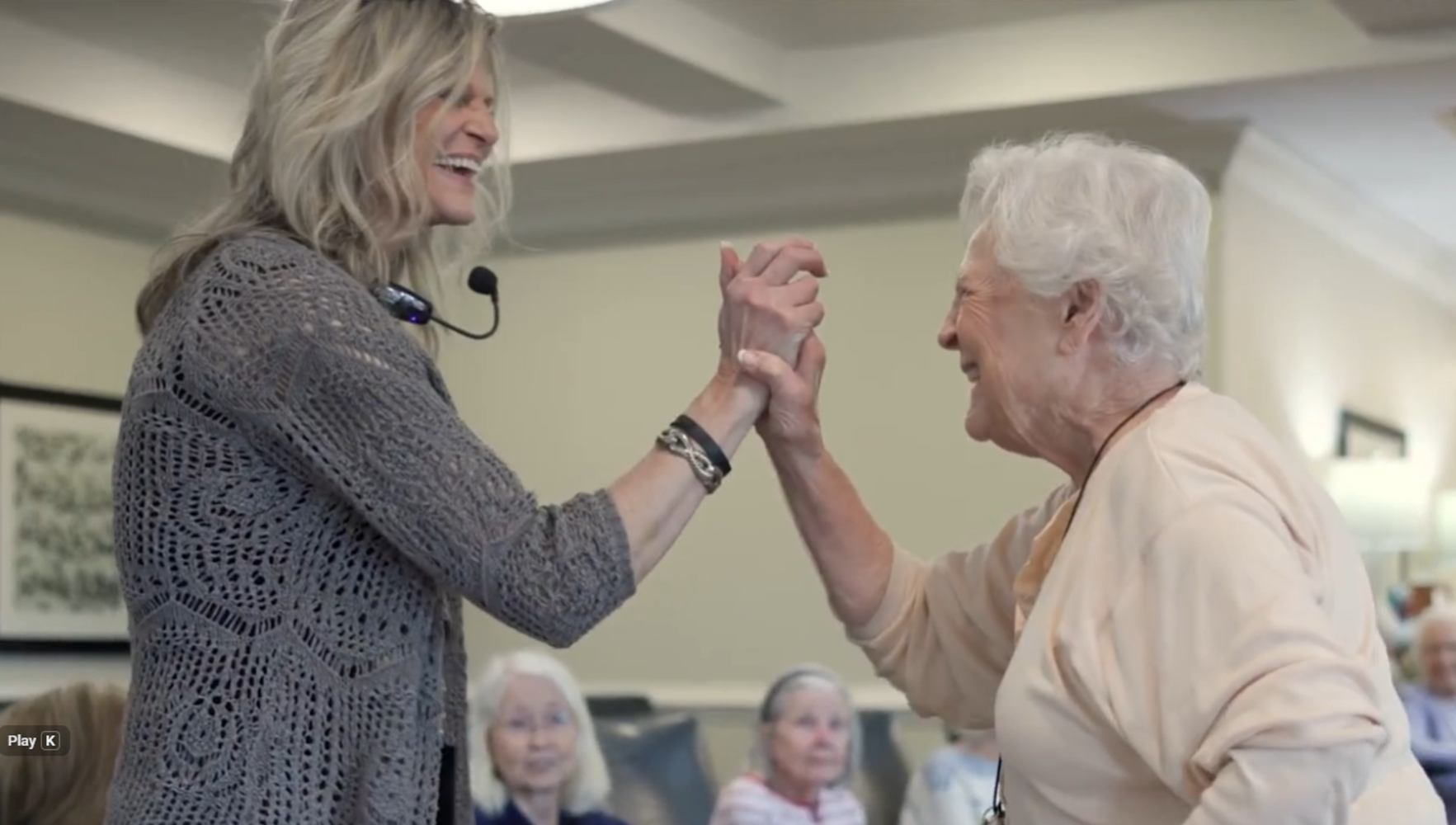 Two women laugh and dance together during a live entertainment event at Arbor Terrace South Forsyth, capturing the joyful, connected spirit of senior living in Suwanee, GA.