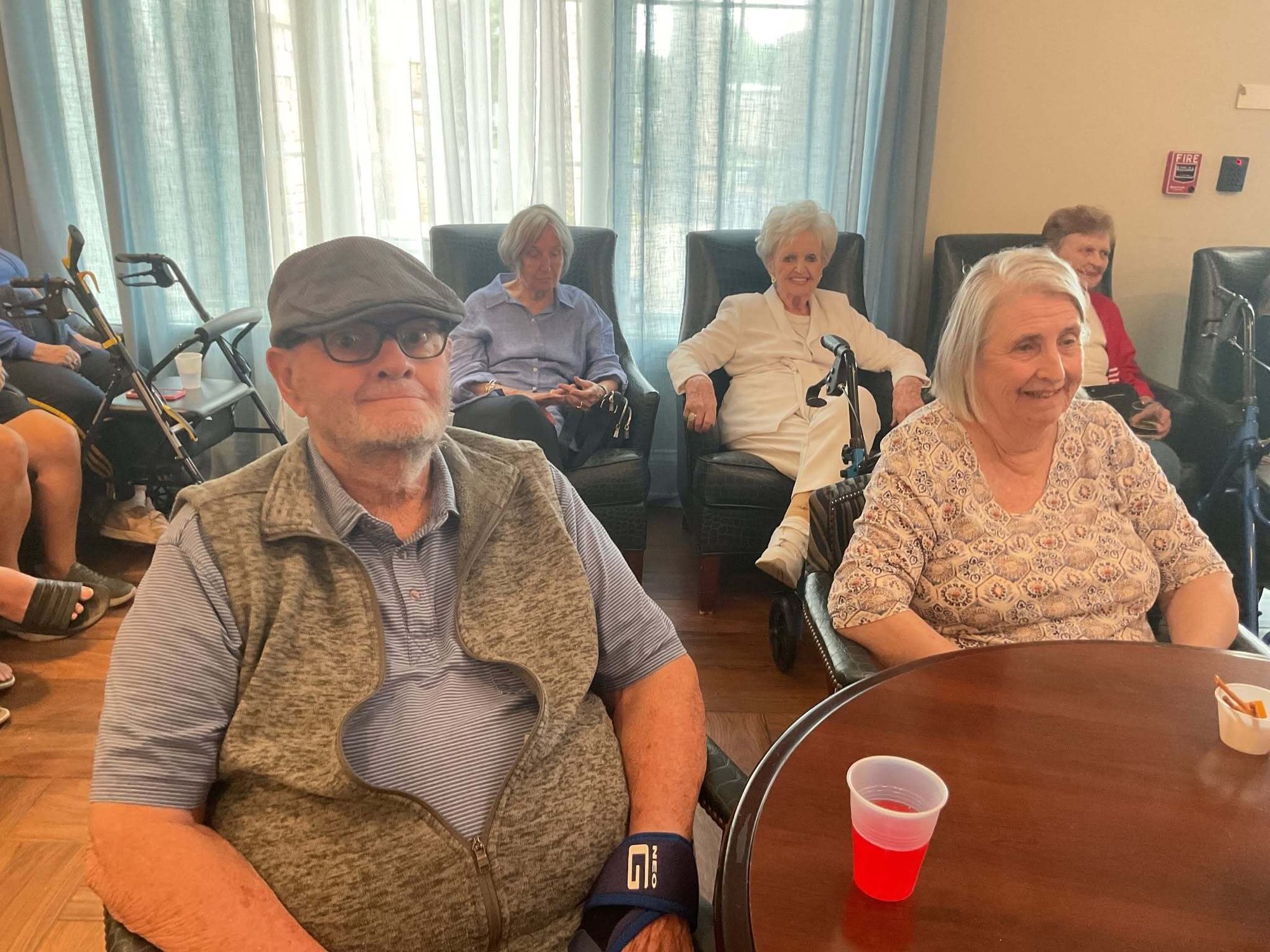 Residents relax together in a cozy common room at Arbor Terrace South Forsyth, a welcoming senior living community in Suwanee, GA.