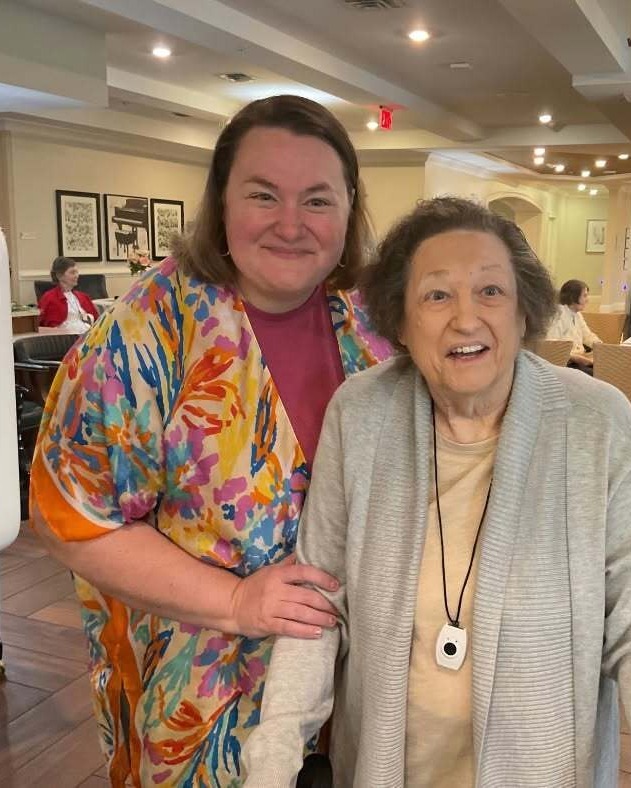 Two women share a warm smile together in the bright dining area at Arbor Terrace South Forsyth, reflecting the close-knit community feel of senior living in Suwanee, GA.