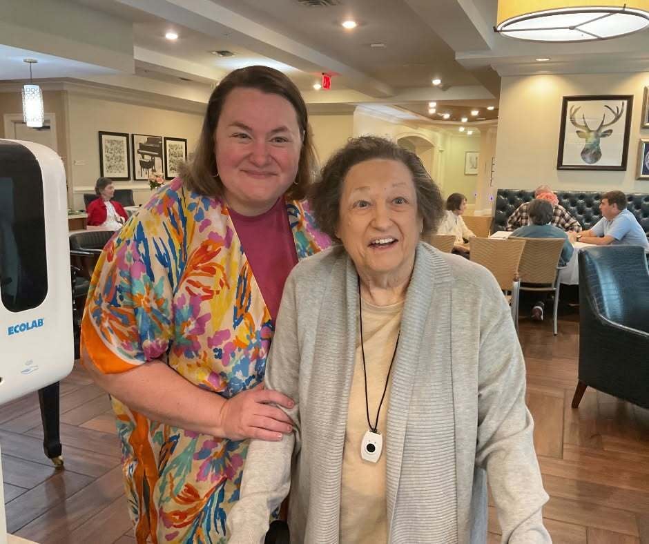 Two women share a warm smile in the inviting dining room at Arbor Terrace South Forsyth, reflecting the close-knit community feel of senior living in Suwanee, GA.