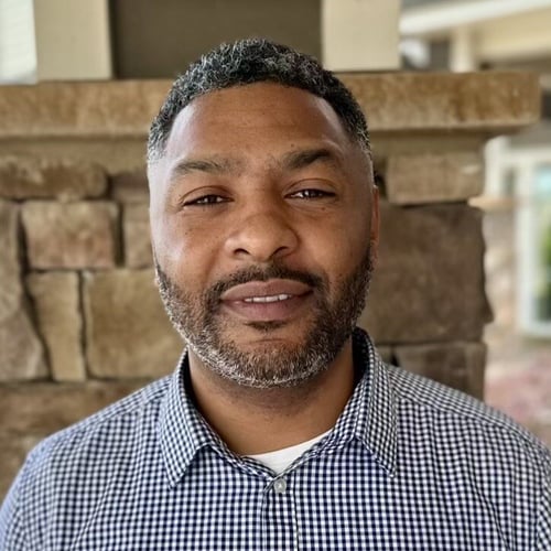 A staff member smiles confidently for a professional headshot at this senior living community in Suwanee, GA.