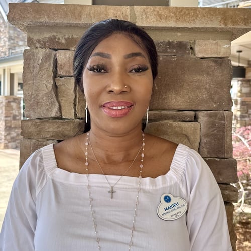 A staff member smiles brightly for a professional headshot at Arbor Terrace South Forsyth senior living community in Suwanee, GA.