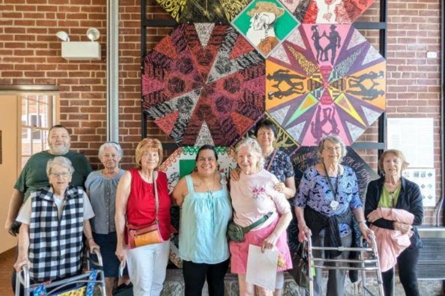 residents smiling in front of museum exhibit
