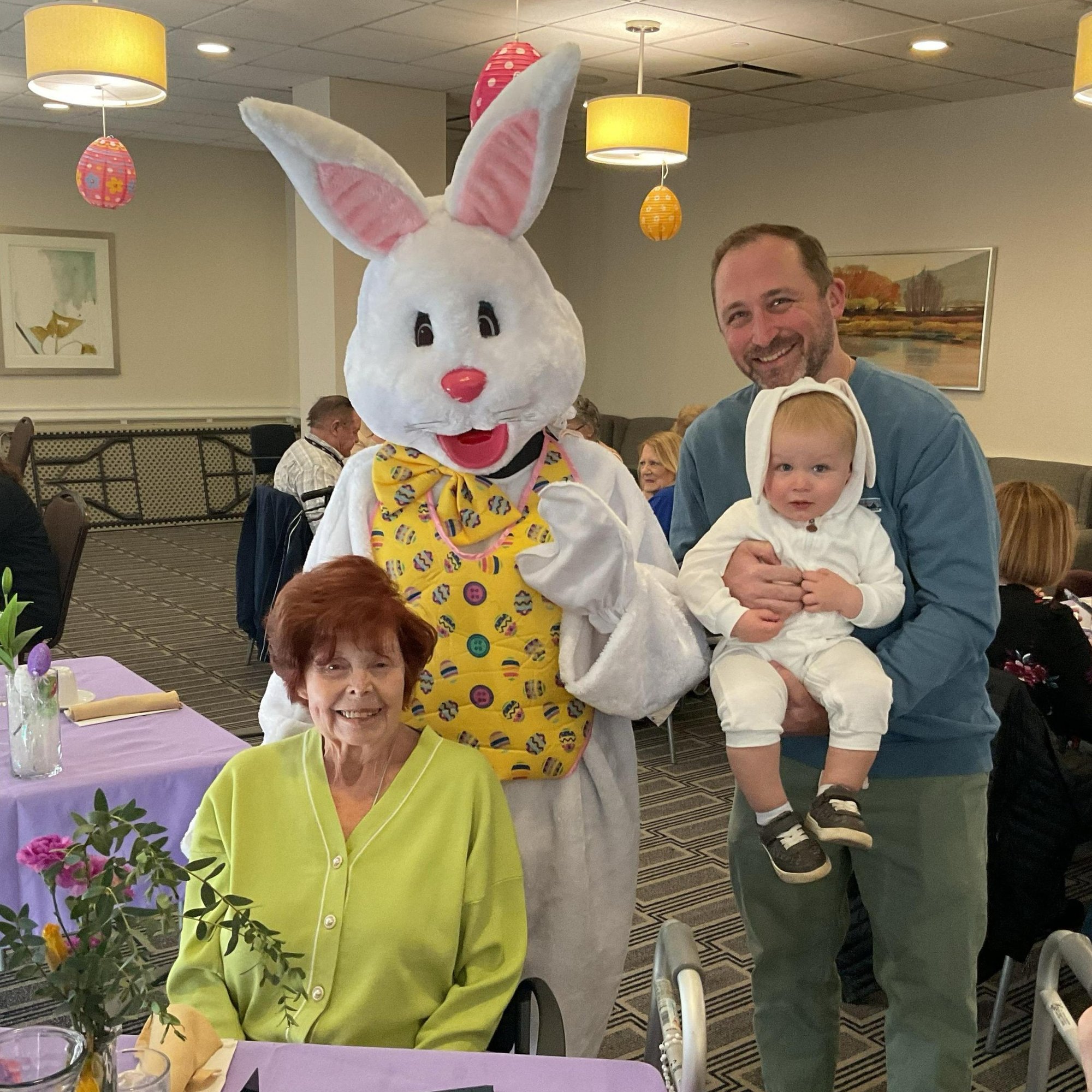 Summit_A resident, a man, and a baby taking a photo with the easter bunny