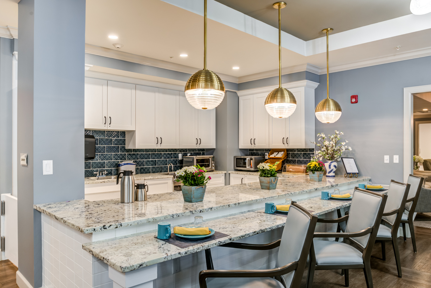 Bar area with chairs, place settings, and hanging lights