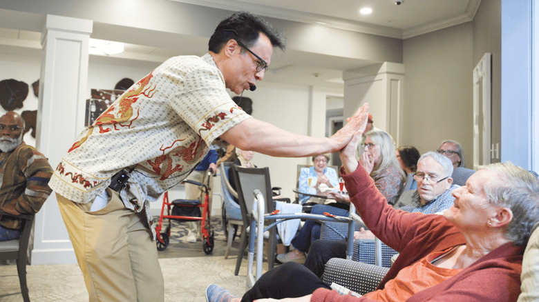 Staff member high fiving a resident during an entertainment event 