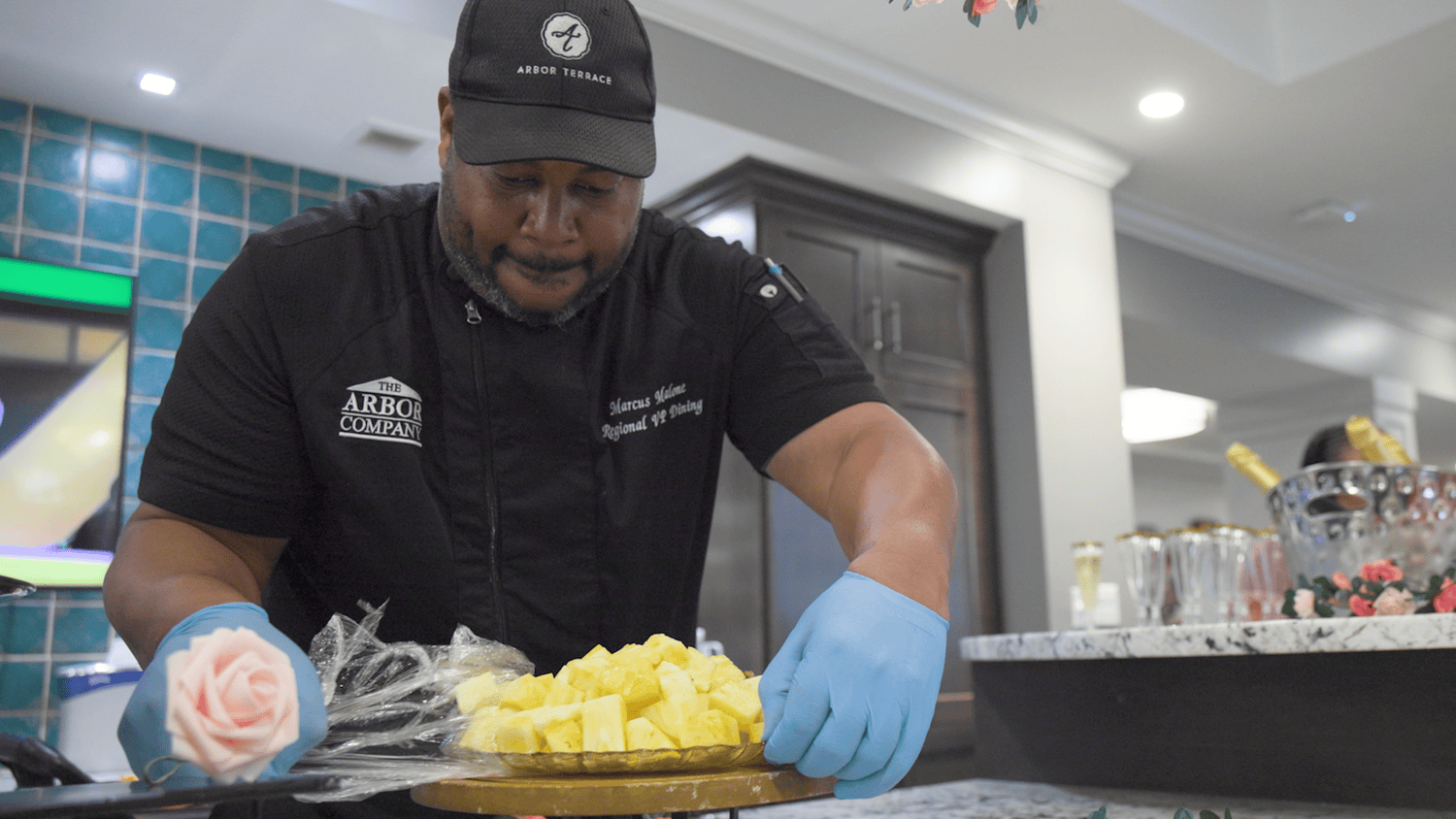 An Arbor Company culinary staff member carefully prepares a fresh fruit platter, highlighting the exceptional dining experience at our senior living community in Gambrills, MD.