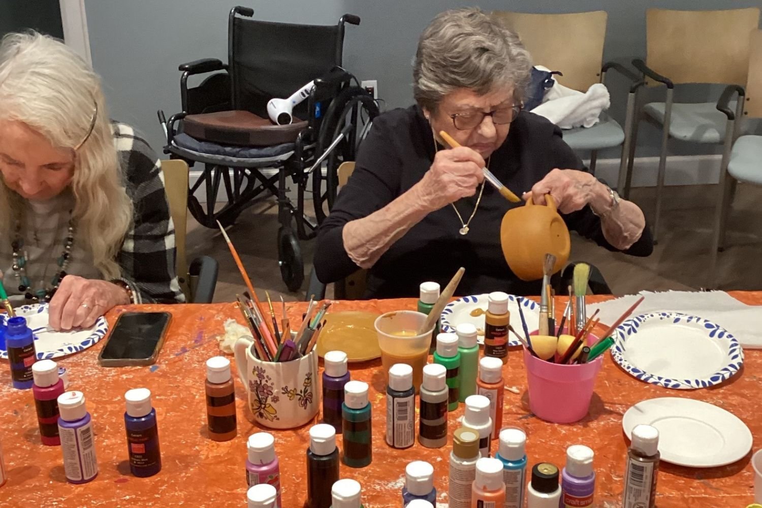 Residents participate in a creative craft activity at Arbor Terrace Waugh Chapel, with art supplies spread across the table, showcasing the enriching and imaginative lifestyle programs available at this senior living community in Gambrills, MD.