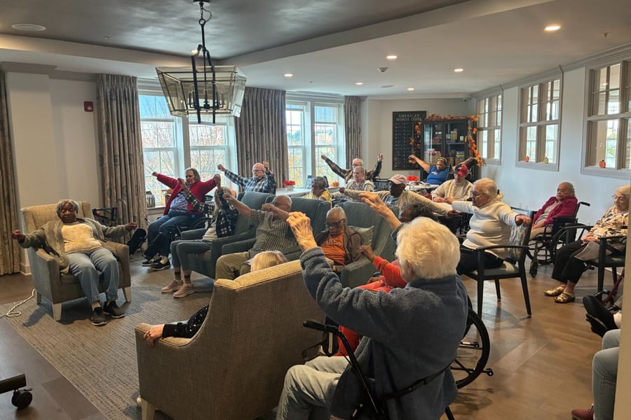 Residents gather in a bright and comfortable common area for a morning program at Arbor Terrace Waugh Chapel, reflecting the warm community atmosphere and engaging daily lifestyle at this assisted living community in Gambrills, MD.