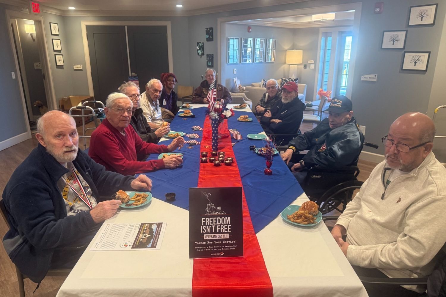 Residents gather around a table for a special Veterans Day program at Arbor Terrace Waugh Chapel, reflecting the meaningful community celebrations and heartfelt recognition events that define senior living at this community in Gambrills, MD.