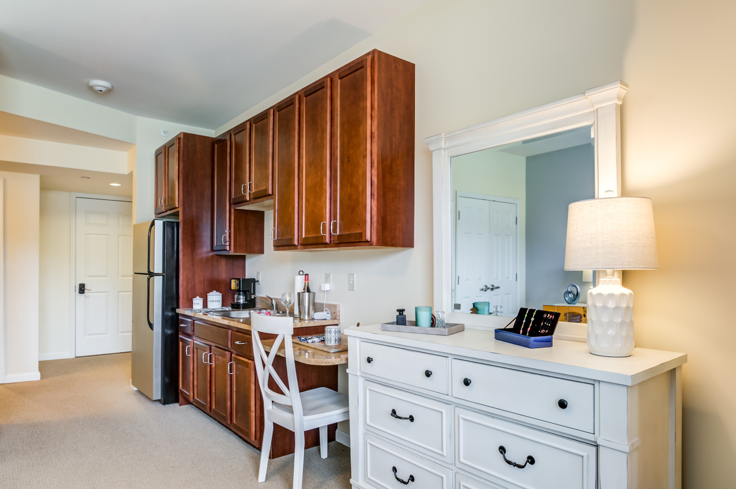 Spacious senior living apartment kitchen and kitchenette at Arbor Terrace Willistown in West Chester, PA, featuring wooden cabinetry and modern appliances.
