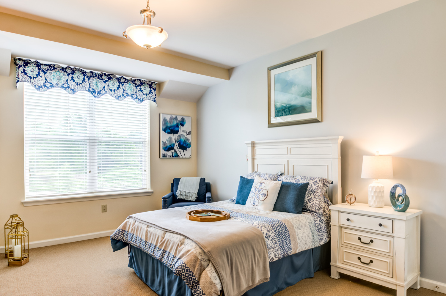 Bright and comfortable senior living apartment bedroom at Arbor Terrace Willistown in West Chester, PA, featuring large windows and cozy furnishings
