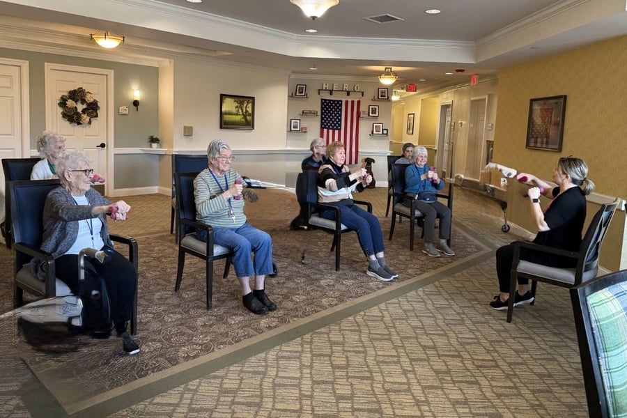 a group of senior residents doing sit-down exercises