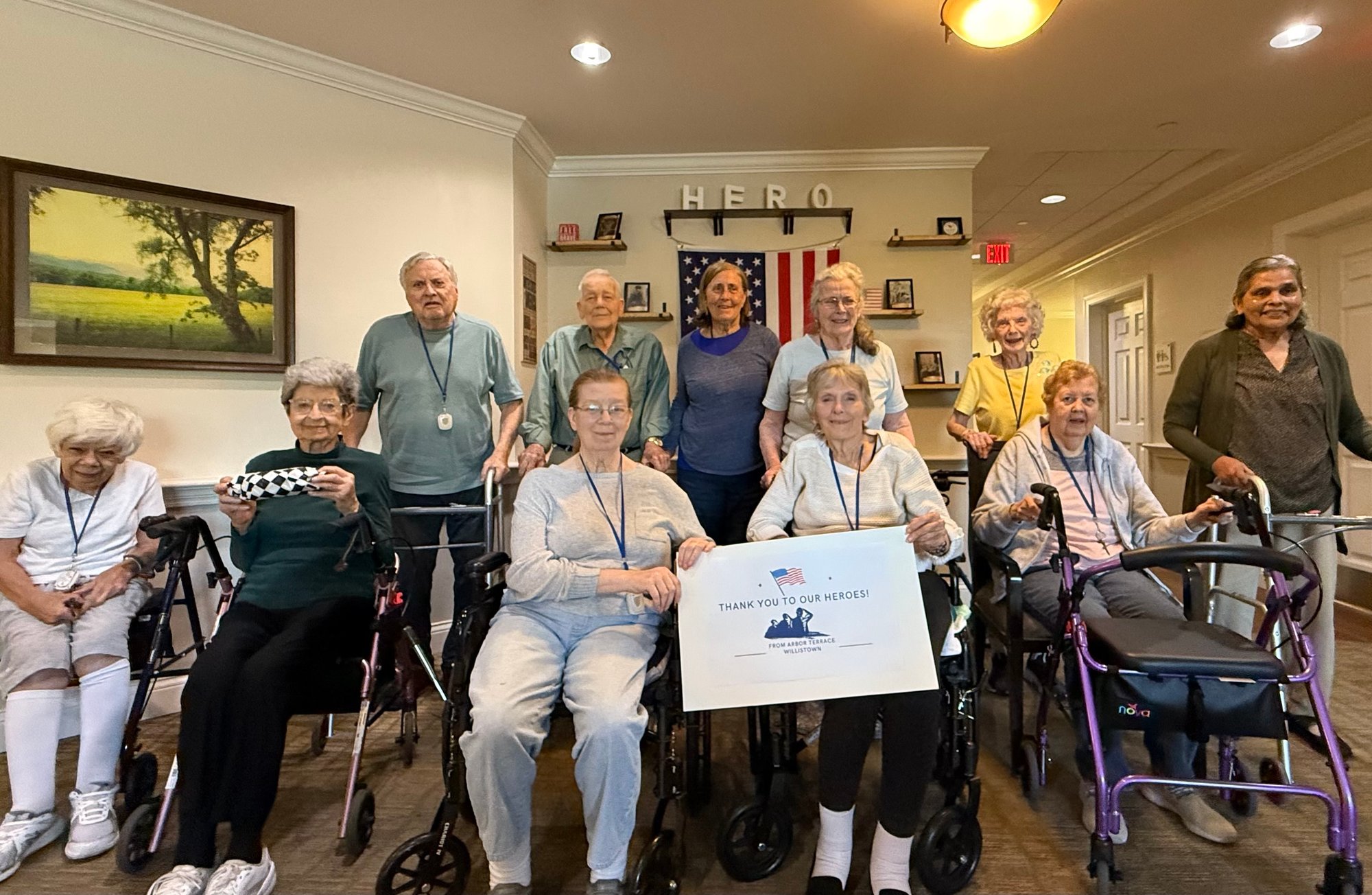 A group of senior living residents from Willistown holding a banner.