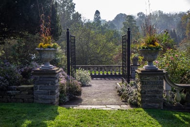 A stone garden pathway lined with lush plantings at Tyler Arboretum, a scenic destination near Arbor Terrace Willistown assisted living West Chester PA.
