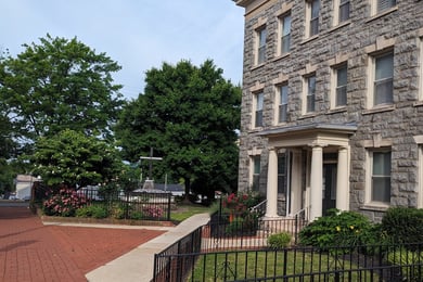 A historic stone building with a brick walkway at the Chester County History Center, near Arbor Terrace Willistown senior living West Chester Pennsylvania.