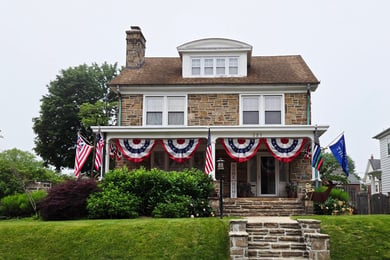 A charming stone house decorated with patriotic bunting in downtown West Chester, PA, near Arbor Terrace Willistown senior living West Chester Pennsylvania.