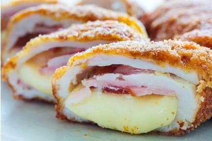A close-up of golden-breaded Chicken Cordon Bleu sliced open to reveal layers of ham and cheese — a fresh take on dining at senior living Lakeway Texas.