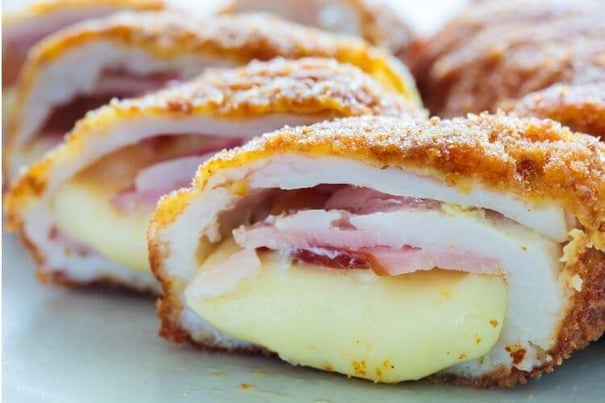 A close-up of golden-breaded Chicken Cordon Bleu sliced open to reveal layers of ham and cheese — a fresh take on dining at senior living Lakeway Texas.