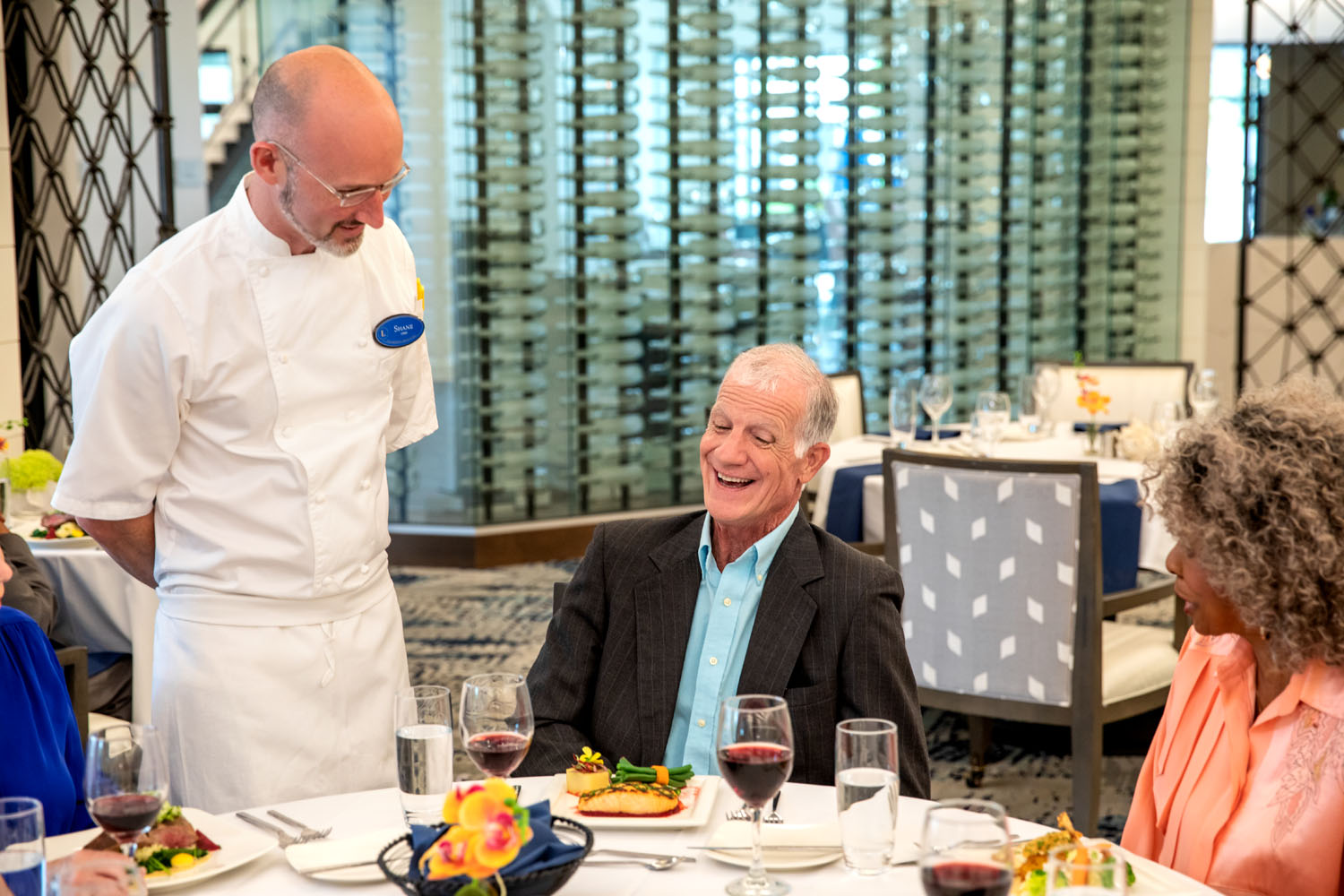 Summit chef talking to resident at dinner table