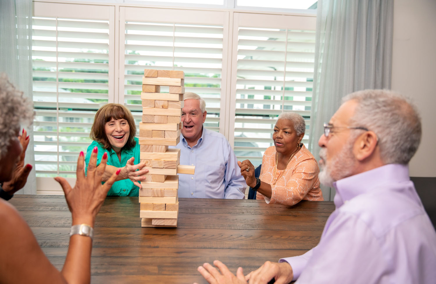 Group of seniors at table, playing a game