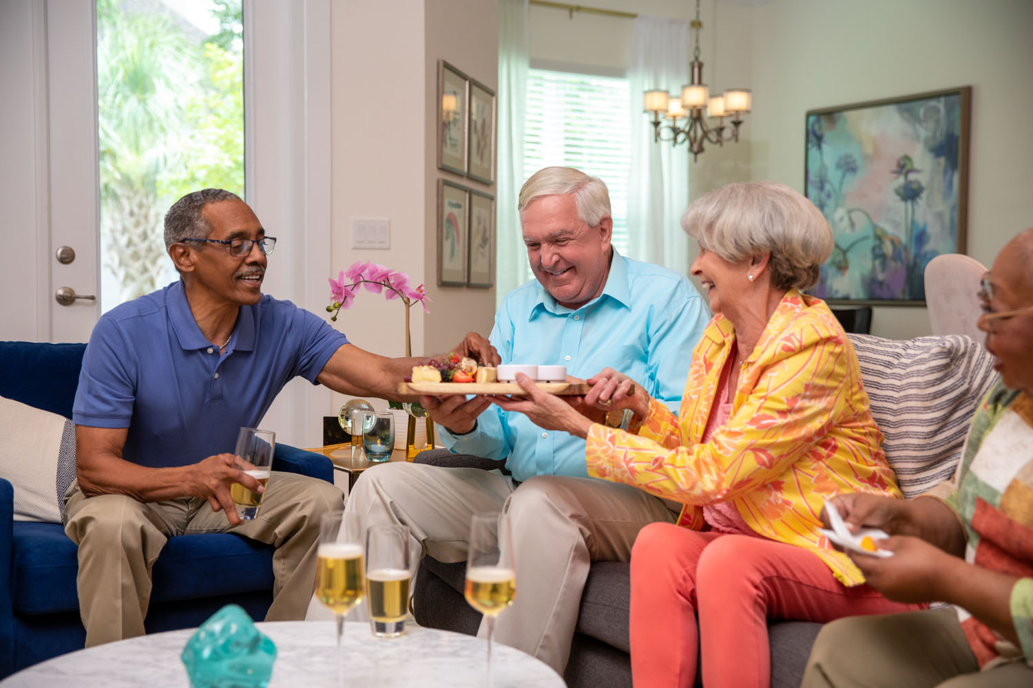 group of senior citizens sharing a plate of food smiling 