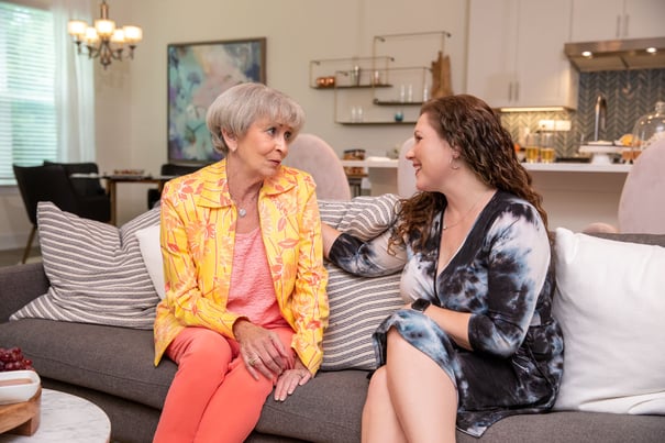 Two women share a warm conversation on a cozy couch, reflecting the wellness-focused care and senior living found in Glenview, Illinois.