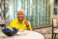 Residents sitting at a round table with a glass of wine and a bread basket
