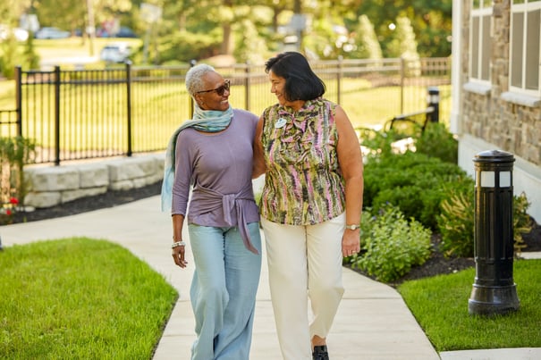 Arbor Terrace Marlton resident and staff member walking down a sidewalk