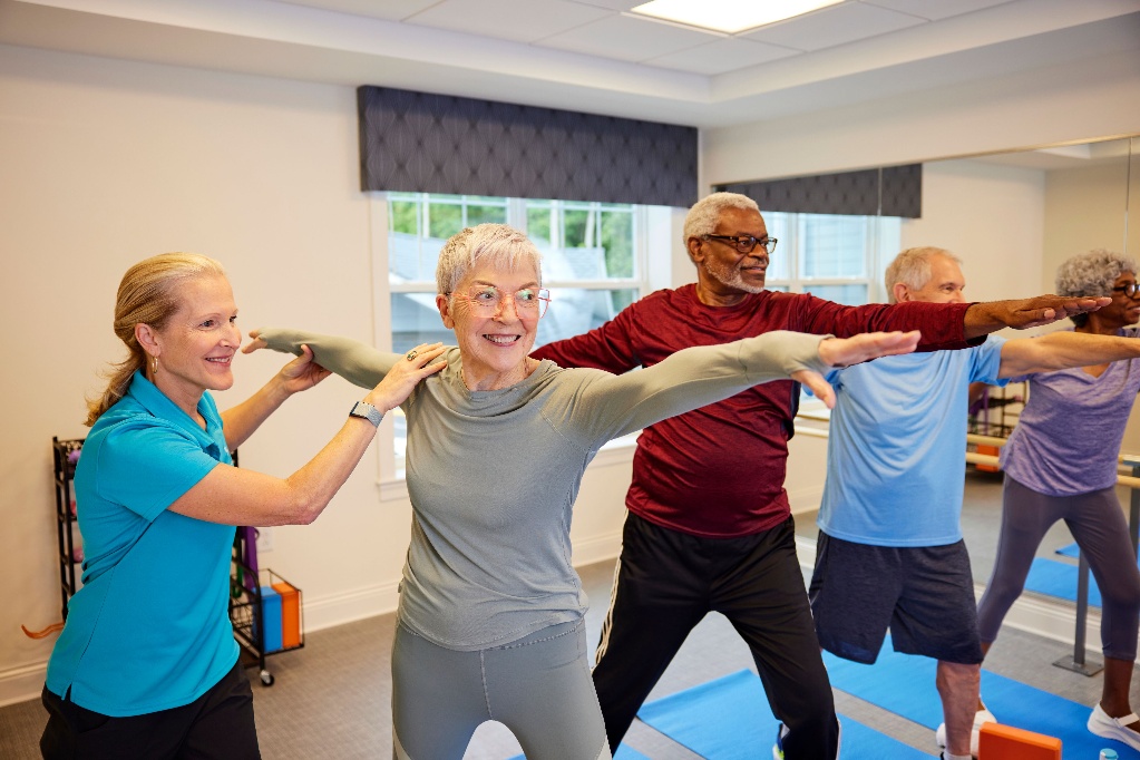 physical therapist helping elderly patients with yoga poses