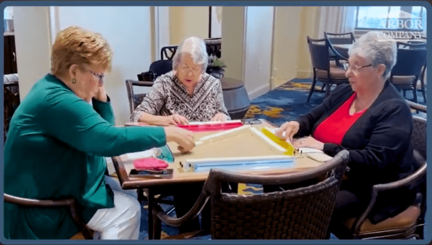 Residents enjoy a friendly game of mahjong together at a cozy table, capturing the social, engaging activities at senior living near Carrollwood, FL.